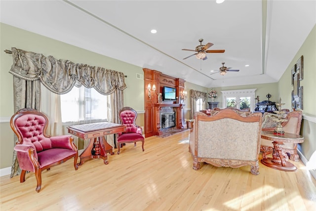 living room featuring a wealth of natural light, a raised ceiling, and wood-type flooring