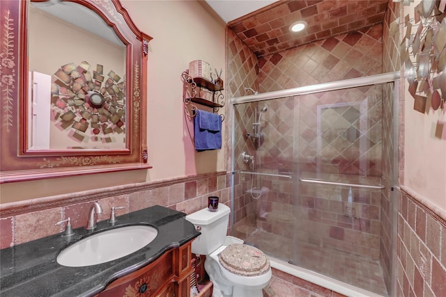 bathroom with vanity, tile walls, an enclosed shower, and toilet