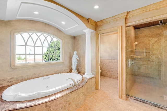 bathroom with decorative columns, shower with separate bathtub, and toilet