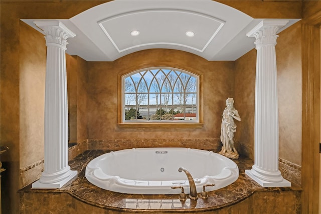 bathroom featuring tiled tub and decorative columns