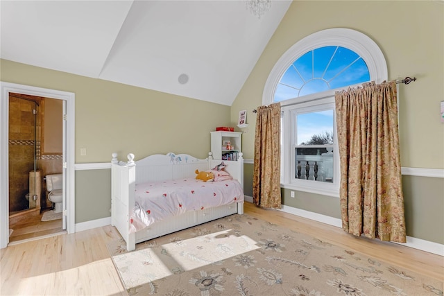 unfurnished bedroom featuring lofted ceiling, hardwood / wood-style flooring, and ensuite bathroom