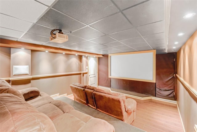 home theater room with a drop ceiling and light hardwood / wood-style flooring