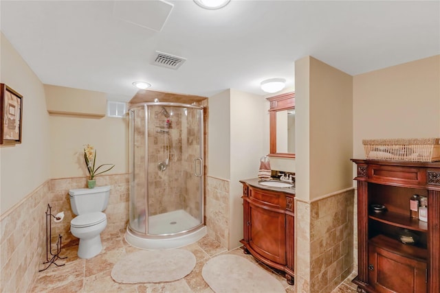 bathroom featuring vanity, tile walls, an enclosed shower, and toilet