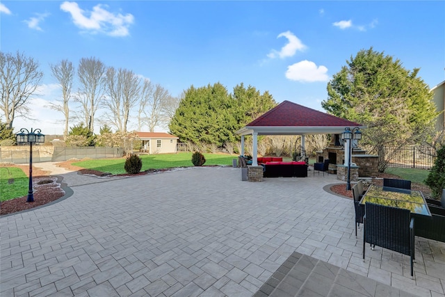 view of patio / terrace featuring a gazebo, an outdoor structure, and an outdoor living space with a fireplace