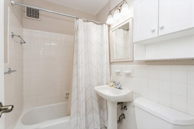 bathroom with tile walls, decorative backsplash, toilet, and shower / bathtub combination with curtain