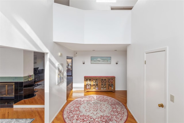 hallway with hardwood / wood-style floors and a towering ceiling