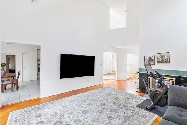 living room with a towering ceiling and light wood-type flooring