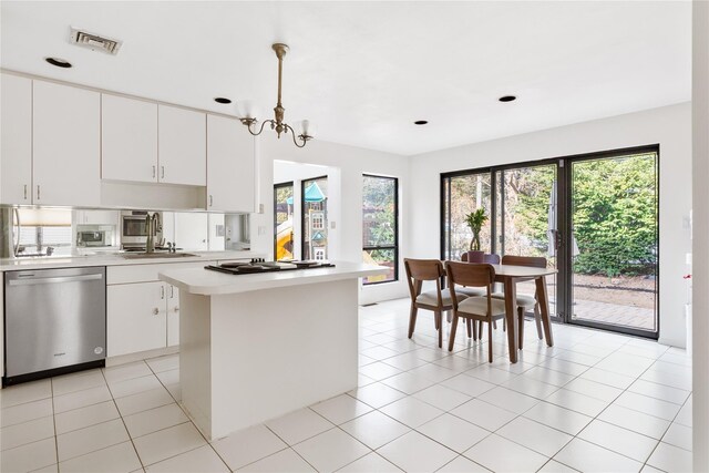 kitchen with decorative light fixtures, white cabinetry, sink, a center island, and stainless steel appliances