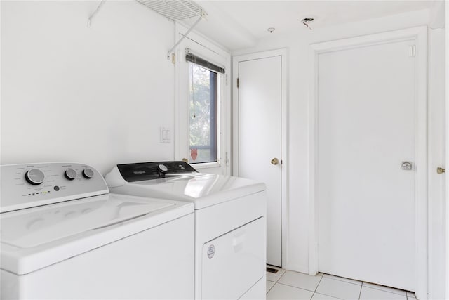 clothes washing area with light tile patterned flooring and washer and clothes dryer