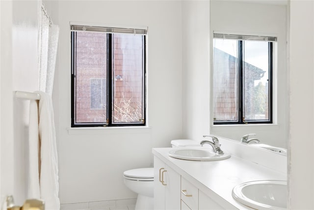 bathroom featuring vanity, tile patterned flooring, toilet, and a healthy amount of sunlight