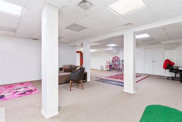 basement with a paneled ceiling and carpet flooring