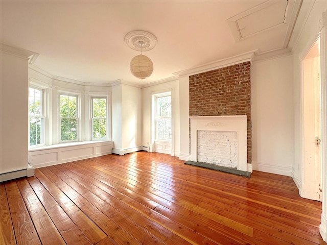 unfurnished living room with hardwood / wood-style flooring, ornamental molding, a baseboard heating unit, and a large fireplace