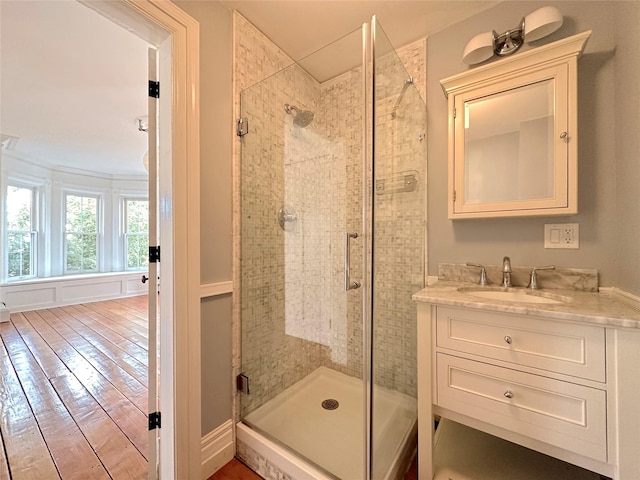 bathroom with vanity, a shower with shower door, and wood-type flooring