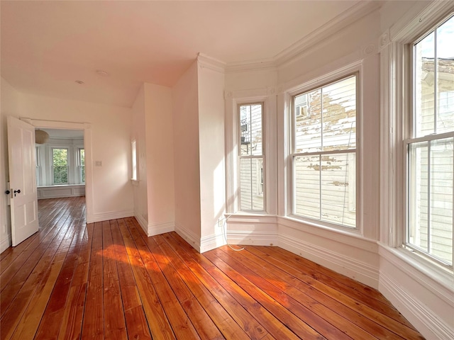 unfurnished room with hardwood / wood-style flooring and crown molding