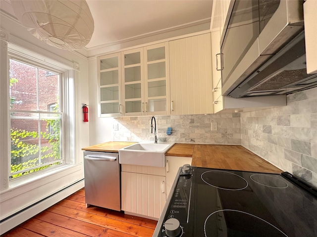 kitchen featuring appliances with stainless steel finishes, sink, butcher block countertops, and a baseboard heating unit