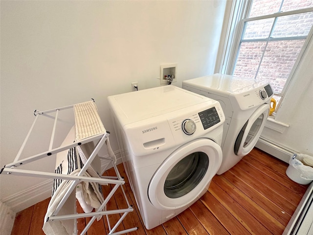 clothes washing area featuring hardwood / wood-style flooring and washer and clothes dryer