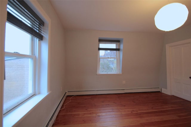 spare room featuring a baseboard radiator and dark hardwood / wood-style flooring