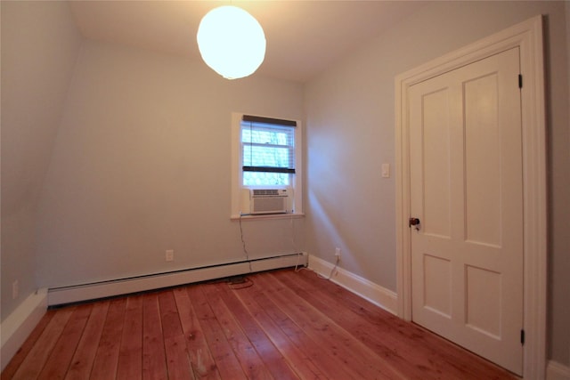 spare room with cooling unit, baseboard heating, and light hardwood / wood-style flooring