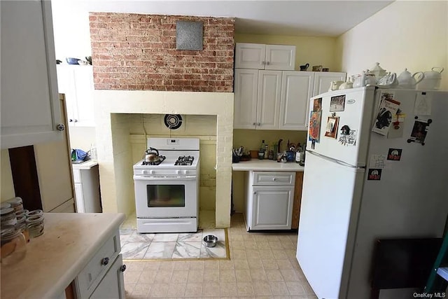 kitchen featuring white appliances, brick wall, and white cabinets