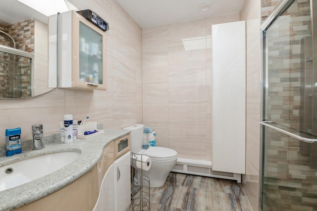 bathroom featuring vanity, toilet, tile walls, and walk in shower