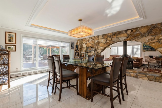 dining area featuring crown molding, a wealth of natural light, light tile patterned floors, and a tray ceiling