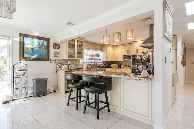 kitchen featuring tasteful backsplash, crown molding, light stone countertops, and exhaust hood