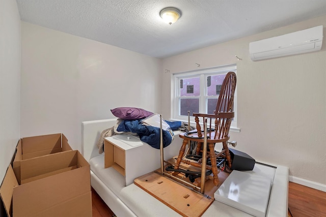 interior space with a wall mounted air conditioner, light hardwood / wood-style floors, and a textured ceiling