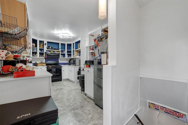 kitchen featuring black gas stove and white cabinets