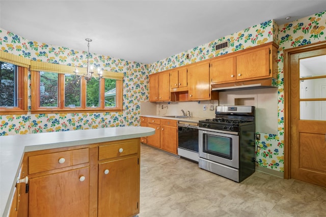18 Kent Rd, Scarsdale, NY 10583 - kitchen with wallpapered walls, stainless steel gas range oven, dishwashing machine, light countertops, and under cabinet range hood