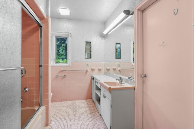18 Kent Rd, Scarsdale, NY 10583 - bathroom with vanity, tile walls, bath / shower combo with glass door, tile patterned flooring, and wainscoting