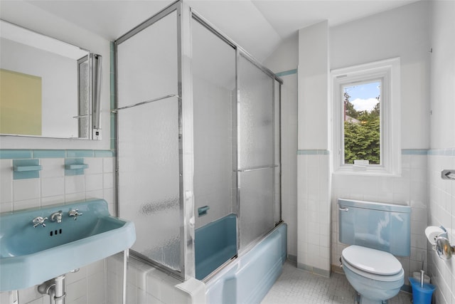 18 Kent Rd, Scarsdale, NY 10583 - full bathroom featuring tile walls, combined bath / shower with glass door, tile patterned flooring, and a wainscoted wall