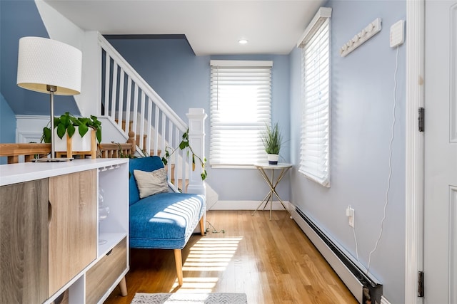 sitting room with baseboard heating and light hardwood / wood-style floors