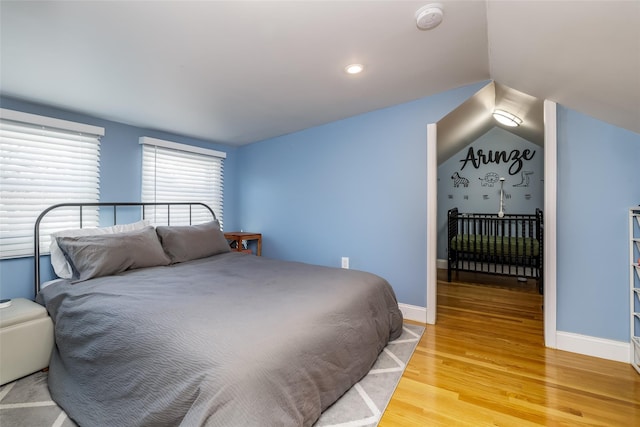 bedroom featuring hardwood / wood-style flooring and vaulted ceiling