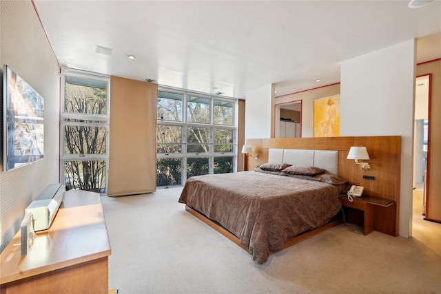 bedroom featuring light colored carpet and expansive windows