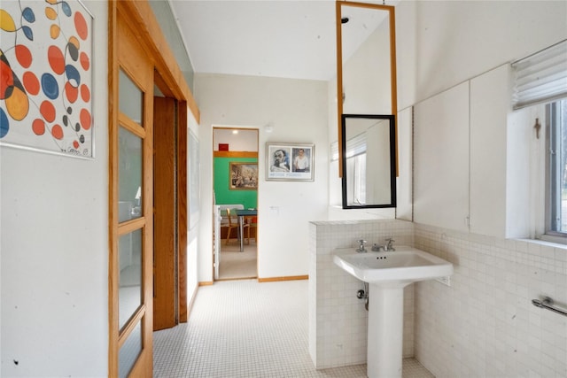 bathroom with tile patterned floors, sink, tile walls, and a wealth of natural light