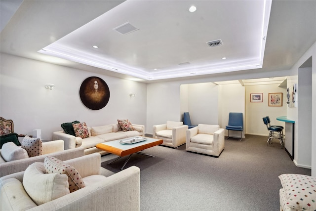 carpeted living room with a tray ceiling