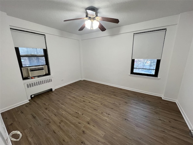 unfurnished room with a textured ceiling, dark hardwood / wood-style flooring, radiator, cooling unit, and ceiling fan