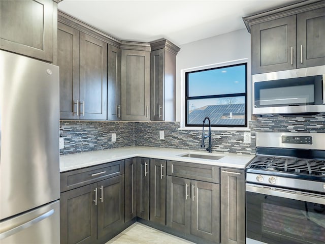 kitchen with appliances with stainless steel finishes, sink, dark brown cabinetry, and decorative backsplash