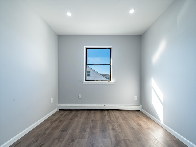 spare room featuring dark hardwood / wood-style flooring and a baseboard radiator