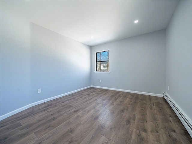 empty room with dark wood-type flooring and a baseboard radiator