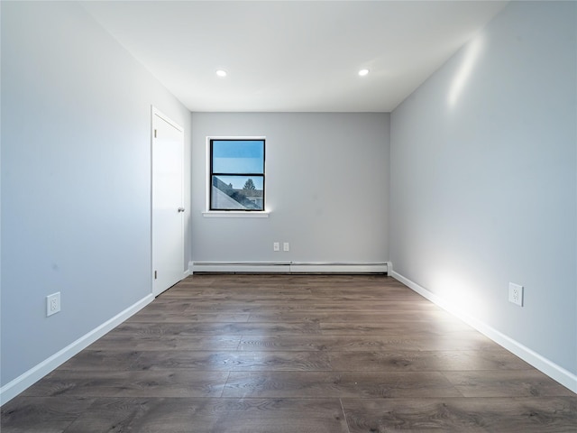 empty room featuring a baseboard radiator and dark hardwood / wood-style floors