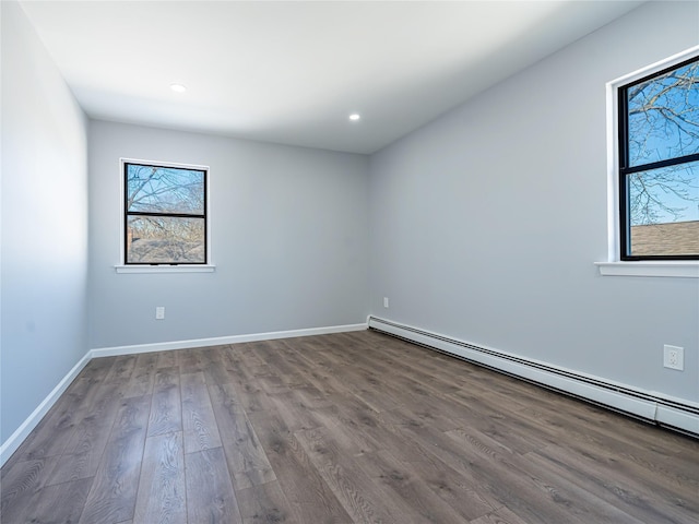 unfurnished room with baseboards, baseboard heating, wood finished floors, and recessed lighting