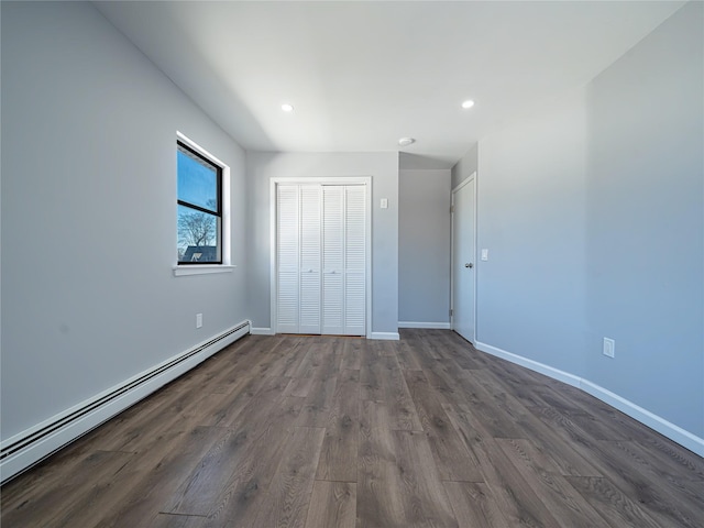 unfurnished bedroom featuring a baseboard radiator, recessed lighting, dark wood-type flooring, baseboards, and a closet