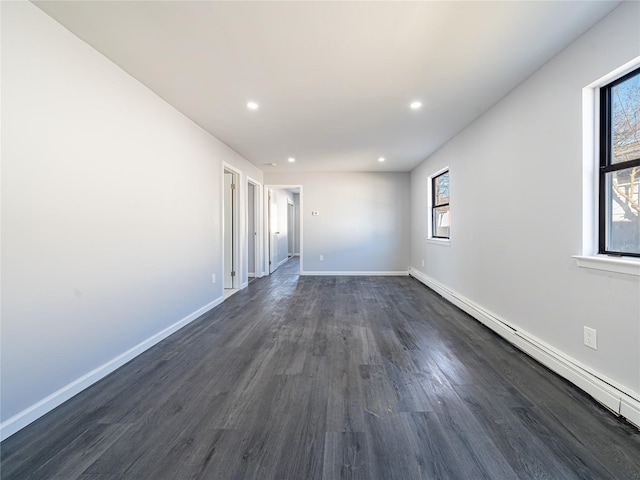 unfurnished room with dark wood-type flooring, a baseboard radiator, baseboards, and recessed lighting