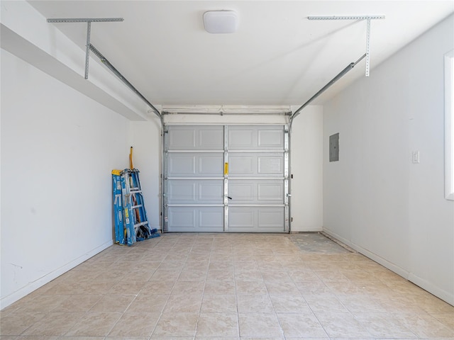 garage featuring electric panel and baseboards