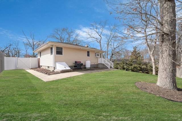 rear view of property featuring a gate, a yard, and fence