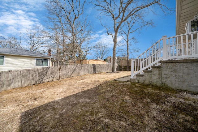 view of yard with fence and stairway