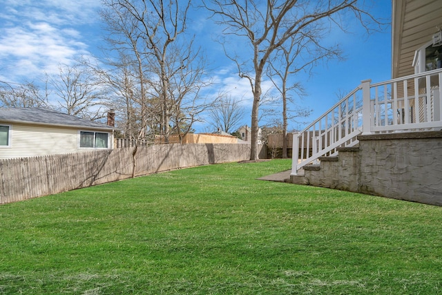 view of yard featuring a fenced backyard and stairs