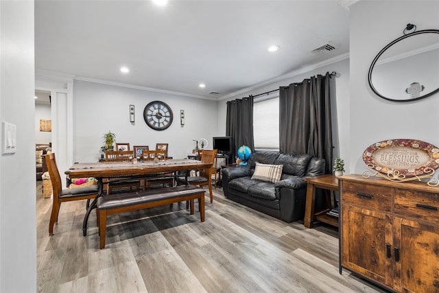 dining area featuring crown molding and light hardwood / wood-style flooring