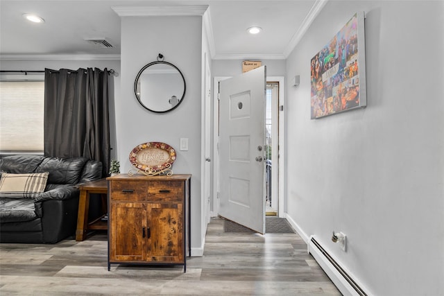 foyer with light wood-type flooring, ornamental molding, and baseboard heating